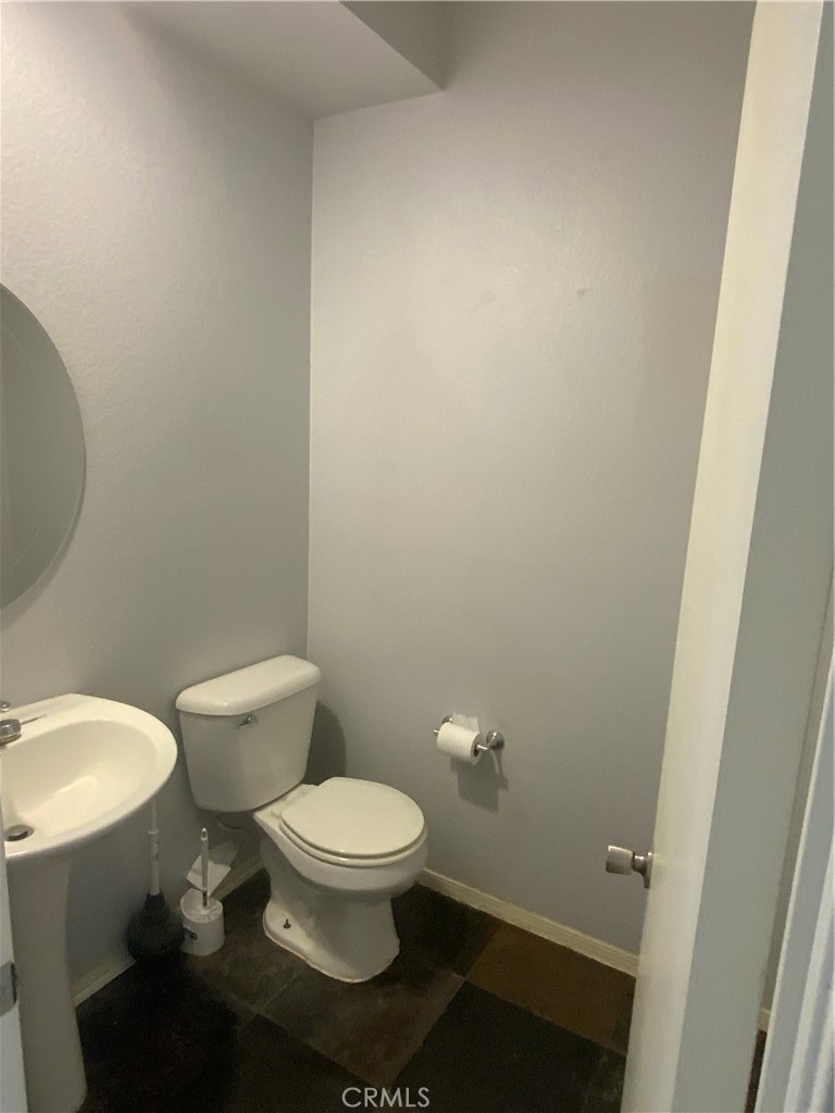 914 Sparrow Way Perris, CA 92571 - Photo 17 of 23 a white toilet sitting next to a white sink and vanity