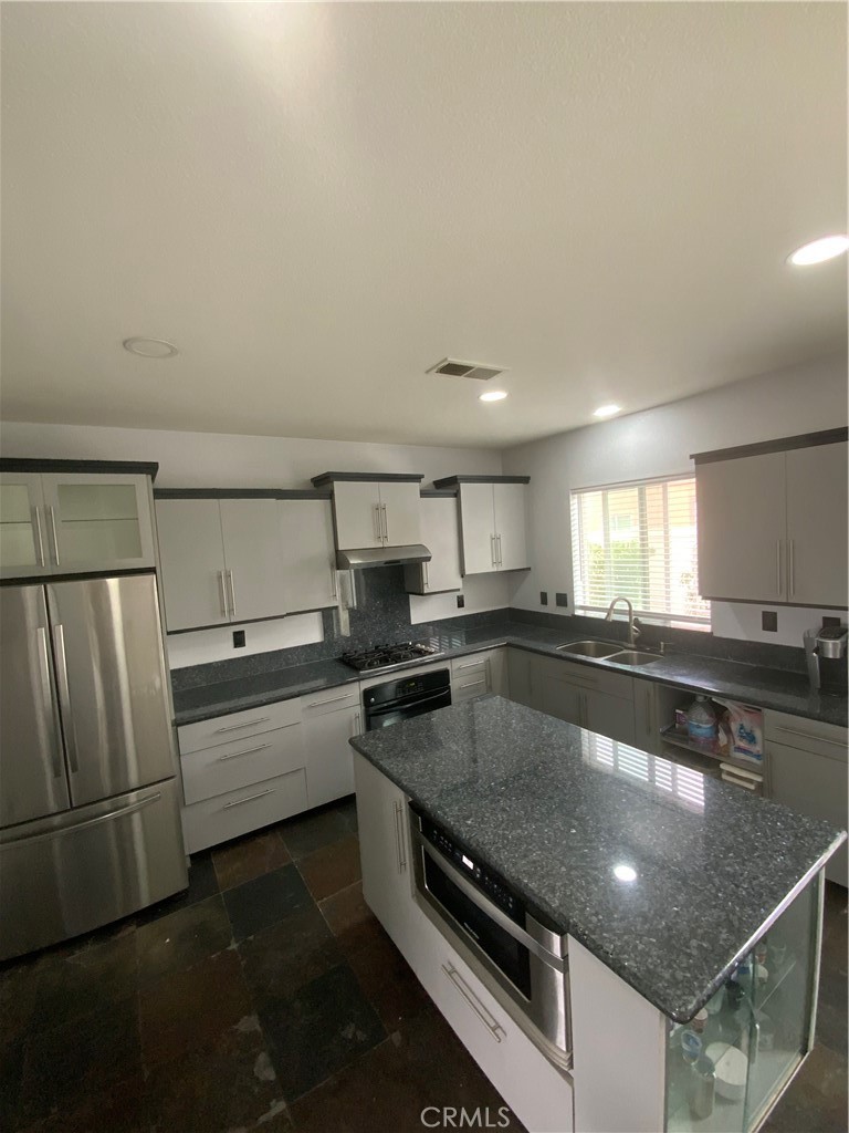 914 Sparrow Way Perris, CA 92571 - Photo 4 of 23 a kitchen with stainless steel appliances granite countertop a sink stove and refrigerator