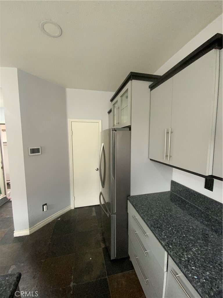 914 Sparrow Way Perris, CA 92571 - Photo 7 of 23 a kitchen with granite countertop a refrigerator and a stove