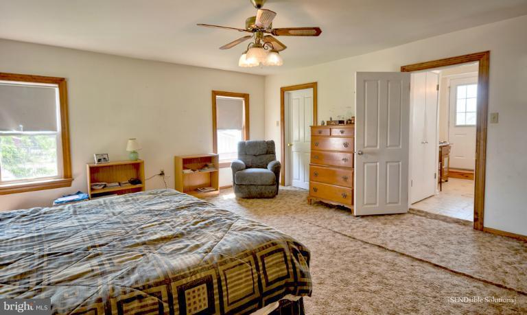 13127 Graceham Road Rocky Ridge, MD 21778 - Photo 12 of 19 a bedroom with a bed and a chandelier