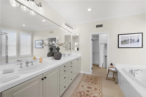 a spacious bathroom with a tub sink and mirror