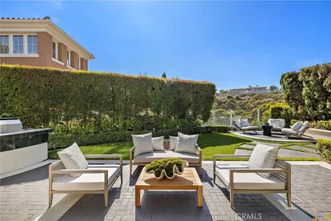 a view of a swimming pool with lawn chairs and a fire pit