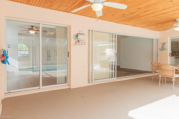 a dining room with furniture large windows and wooden floor
