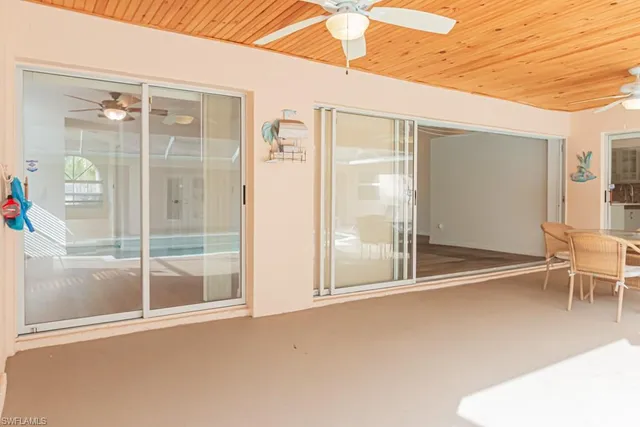 a dining room with furniture large windows and wooden floor