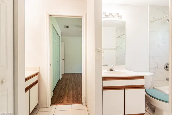 a bathroom with a sink mirror and a bathtub