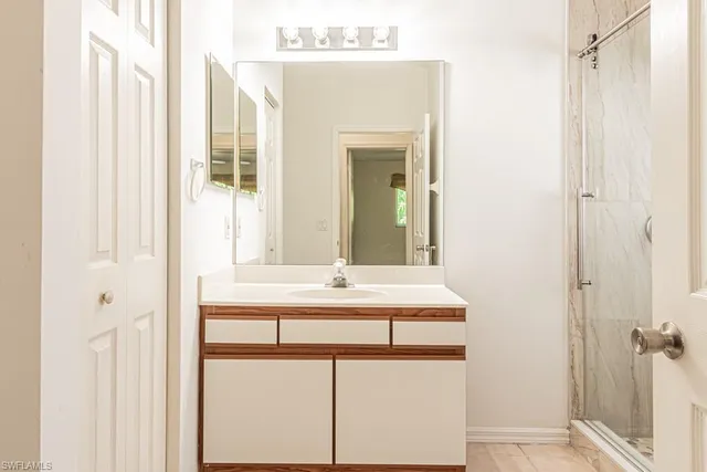 a bathroom with a double vanity sink toilet and shower