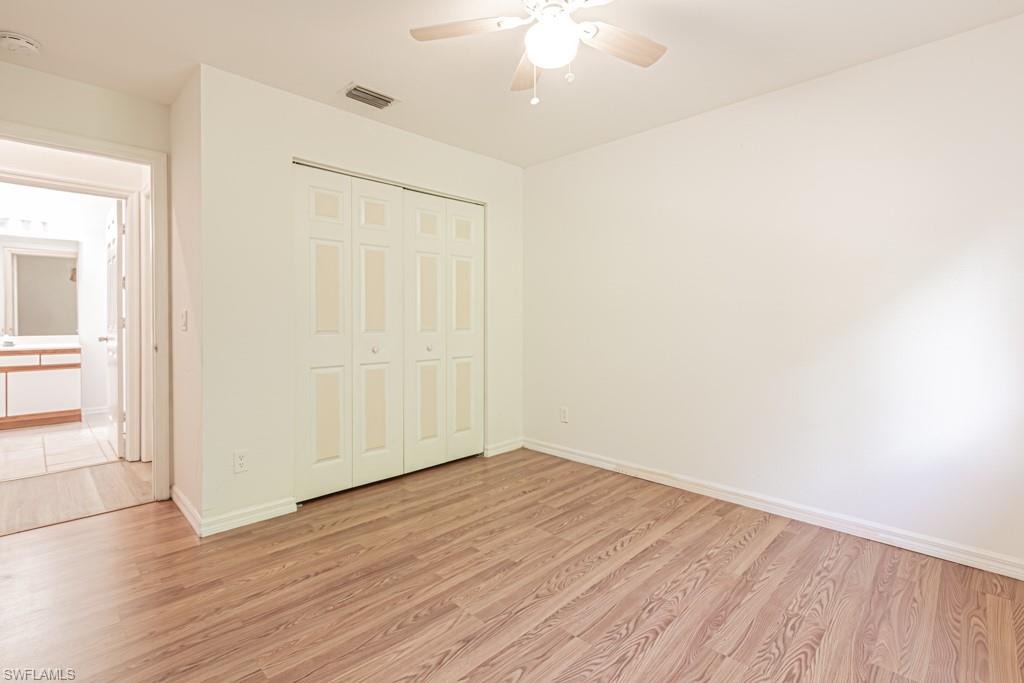 590 6th Street Northeast Naples, FL 34120 - Photo 26 of 50 Unfurnished bedroom with ceiling fan and a closet