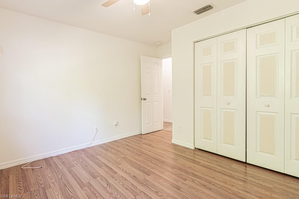 590 6th Street Northeast Naples, FL 34120 - Photo 27 of 50 Unfurnished bedroom with ceiling fan and a closet