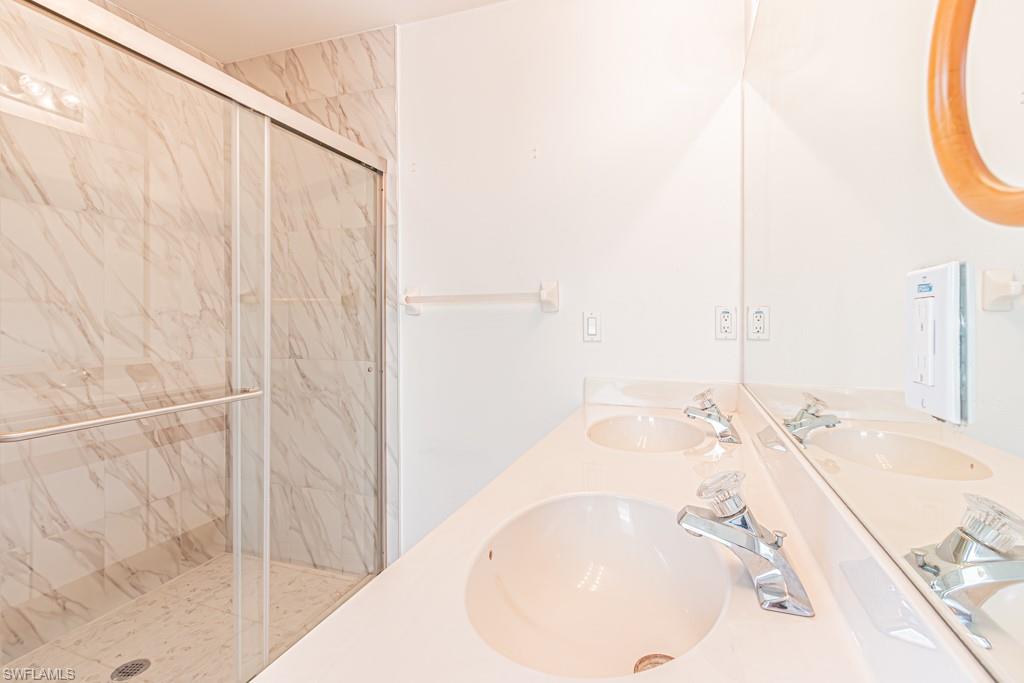 590 6th Street Northeast Naples, FL 34120 - Photo 32 of 50 Bathroom with vanity, a walk-in shower, spa-style bathtub, and light tile patterned floors