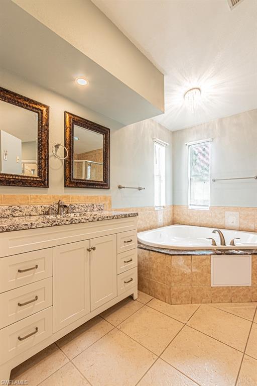 590 6th Street Northeast Naples, FL 34120 - Photo 40 of 50 Bathroom featuring a spa-style bathtub, a shower stall, vanity, and tile patterned flooring