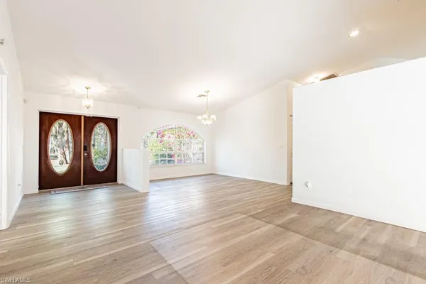 an empty room with large window and wooden floor