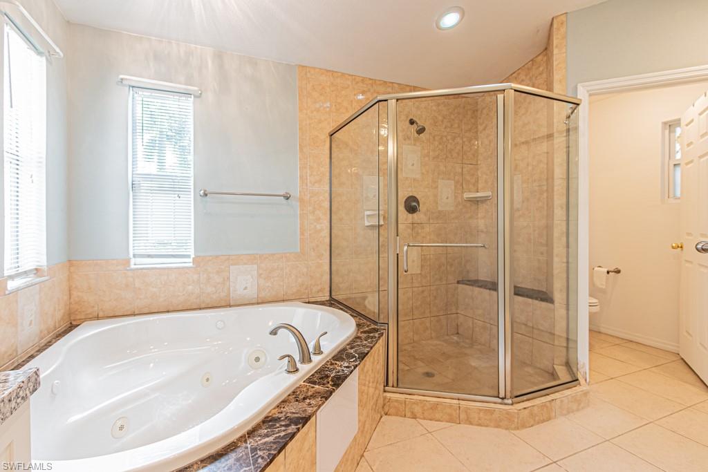 590 6th Street Northeast Naples, FL 34120 - Photo 41 of 50 Bathroom with a tub with jets, light tile patterned flooring, a shower stall, recessed lighting, and vanity