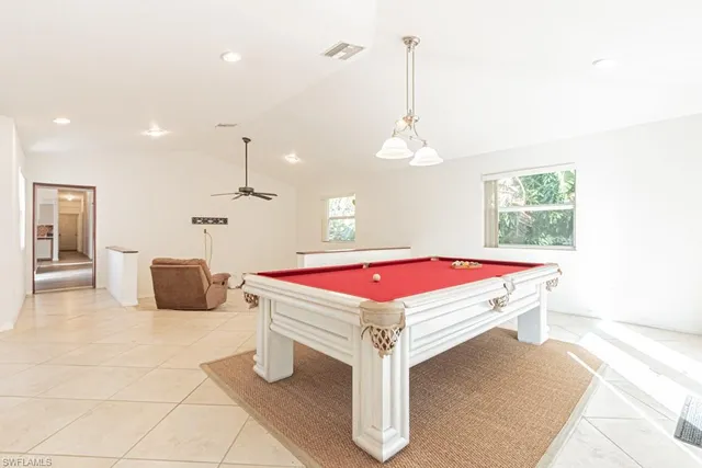 a room with pool table and windows