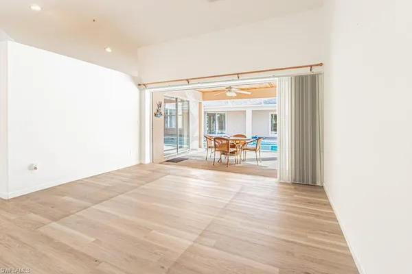 a view of a hallway with dining room and wooden floor