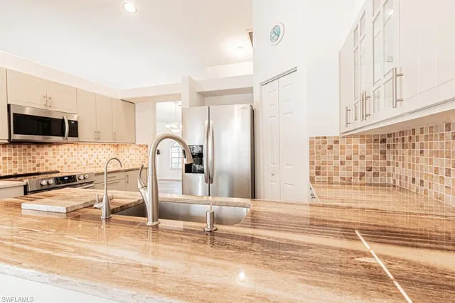 a view of a kitchen with granite countertop a stove a sink and a microwave