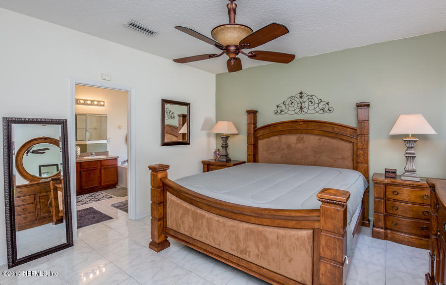 9141 Raptor Drive Jacksonville, FL 32221 - Photo 11 of 25 a bedroom with bed and a chandelier