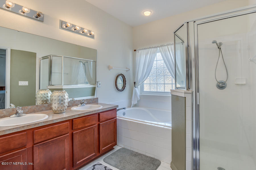 9141 Raptor Drive Jacksonville, FL 32221 - Photo 13 of 25 a bathroom with a tub sink shower and mirror