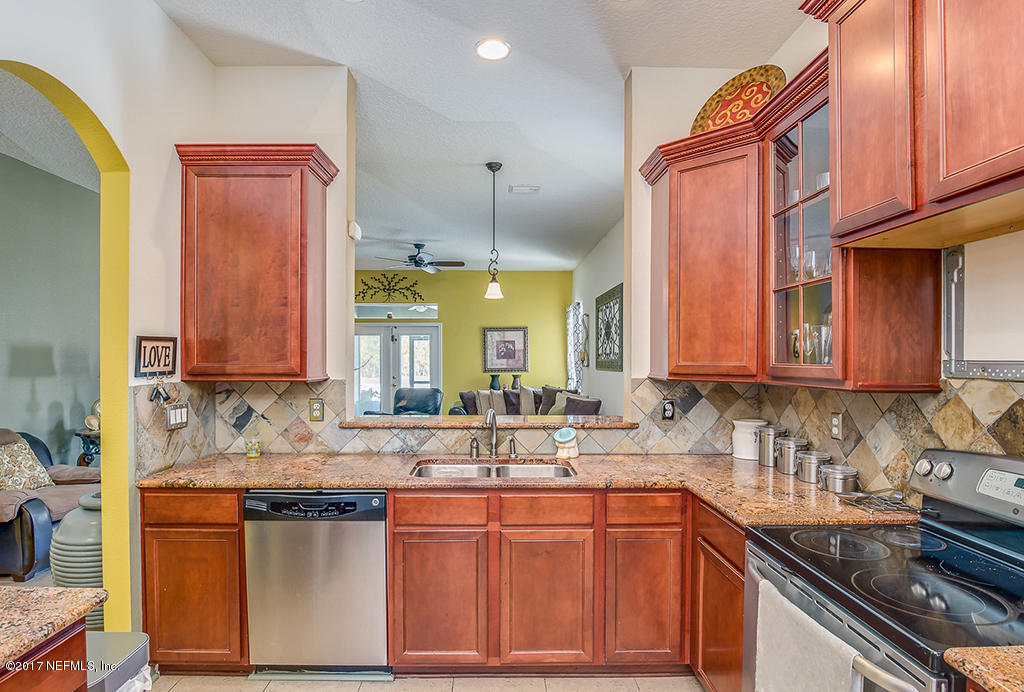 9141 Raptor Drive Jacksonville, FL 32221 - Photo 5 of 25 a kitchen with stainless steel appliances granite countertop a sink stove and cabinets