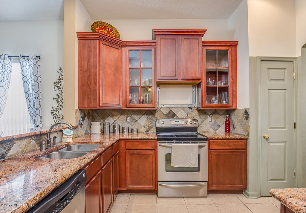 9141 Raptor Drive Jacksonville, FL 32221 - Photo 6 of 25 a kitchen with stainless steel appliances granite countertop a sink stove and cabinets