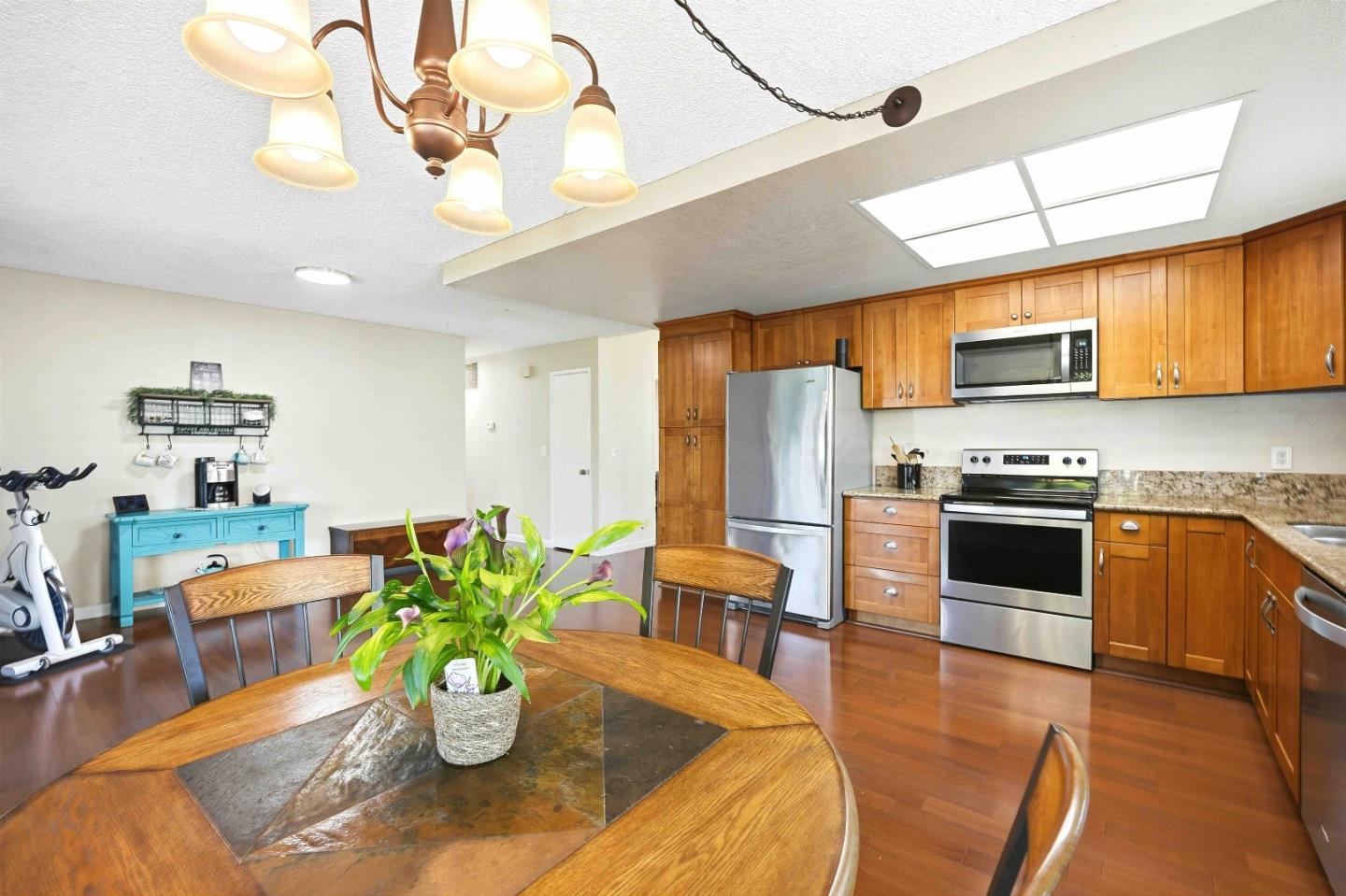 925 Blake Court Gilroy, CA 95020 - Photo 11 of 30 a kitchen with stainless steel appliances granite countertop a refrigerator a stove top oven a dining table and chairs with wooden floor