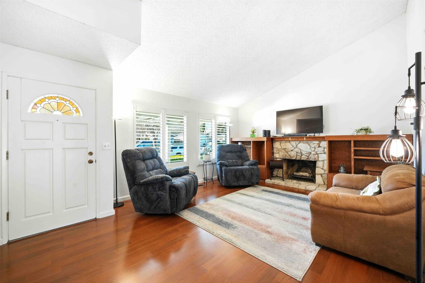 925 Blake Court Gilroy, CA 95020 - Photo 5 of 30 a living room with furniture a fireplace and a flat screen tv