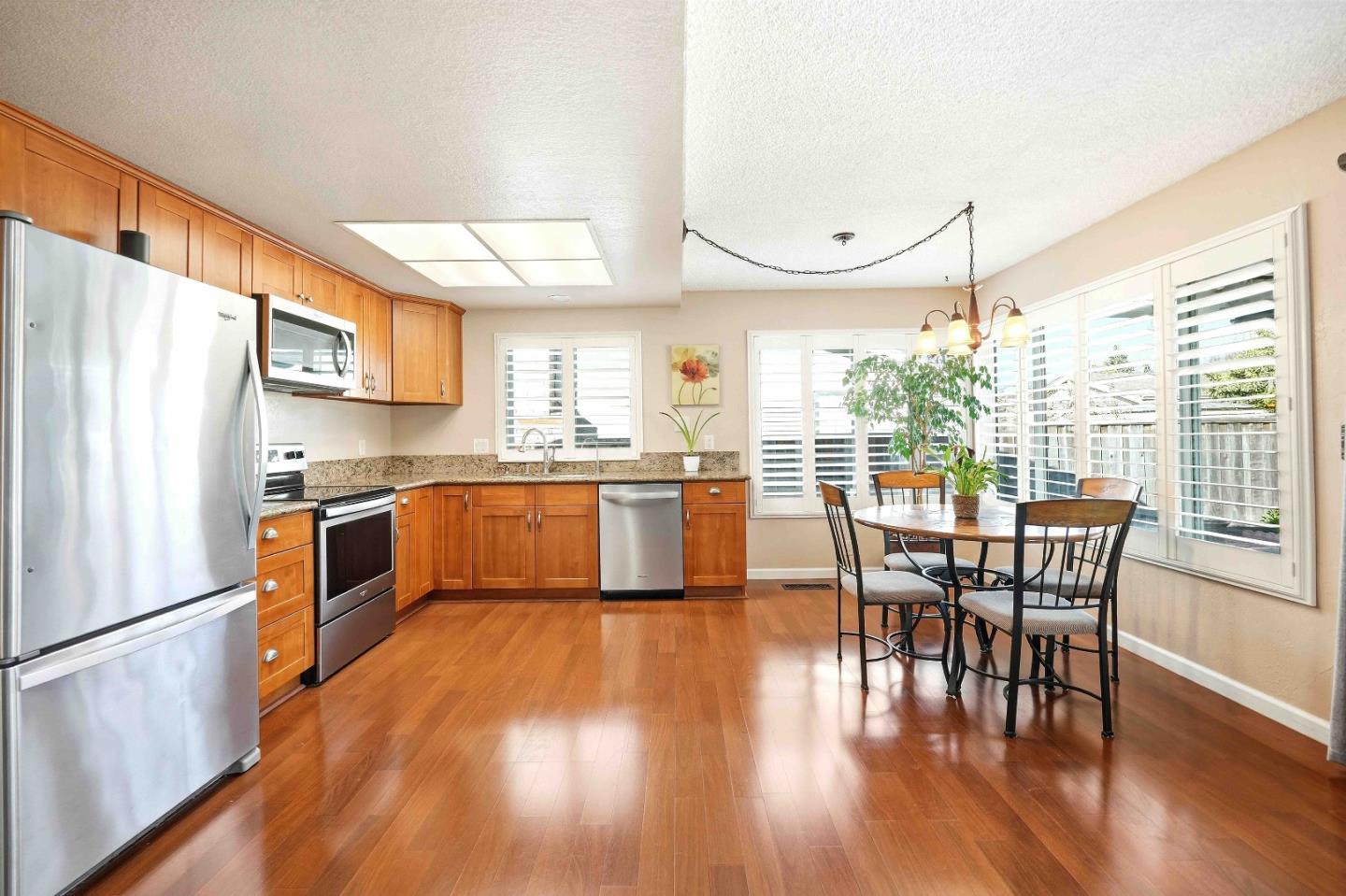 925 Blake Court Gilroy, CA 95020 - Photo 8 of 30 a kitchen with stainless steel appliances granite countertop a stove a kitchen island a dining table and chairs
