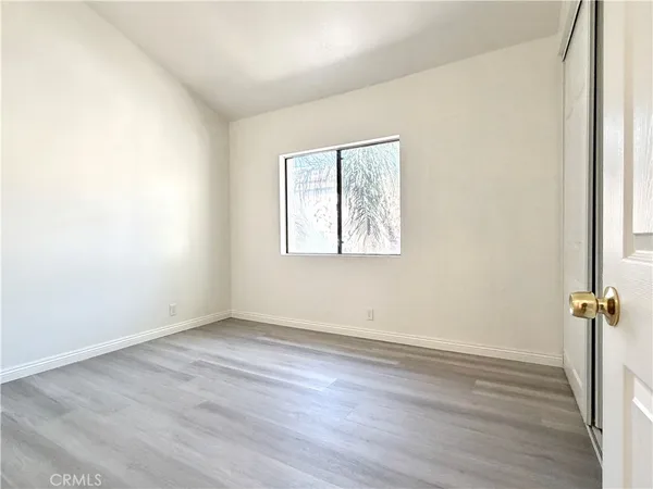 a view of a house with palm trees and a small yard