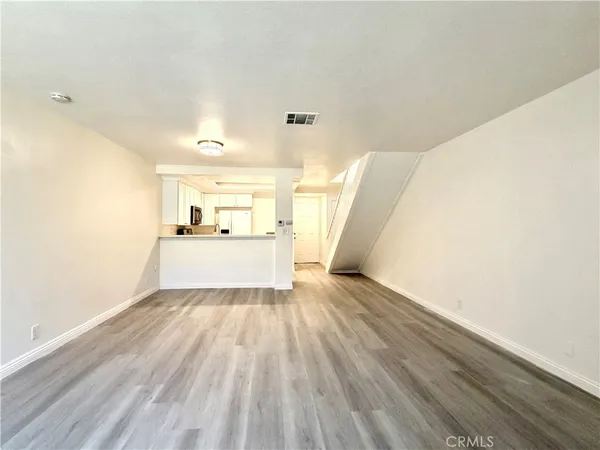 a view of a hallway to a house with wooden floor