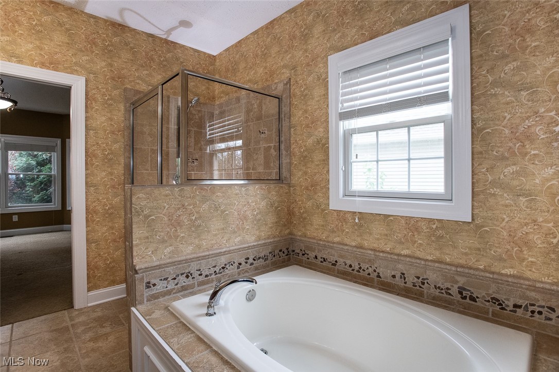 630 Rundle Street Lagrange, OH 44050 - Photo 22 of 49 Bathroom with wallpapered walls, a bath, plenty of natural light, a stall shower, and tile patterned flooring