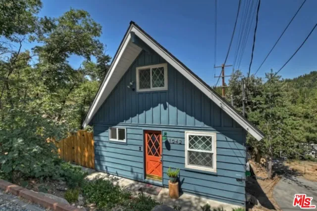 a front view of a house with a tree