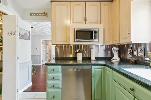 a kitchen with granite countertop a stove a sink and a microwave