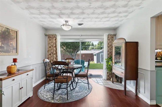 a dining room with furniture a large window and wooden floor