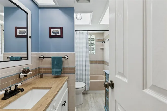 a bathroom with a sink vanity granite tub and shower