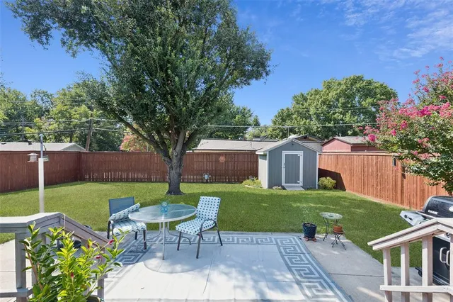 a view of a chair and table in backyard of the house