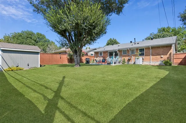 a view of a house with a big yard and large trees