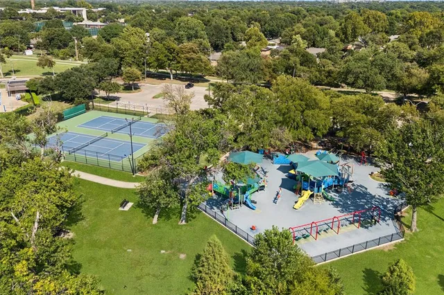 an aerial view of residential houses with outdoor space and trees