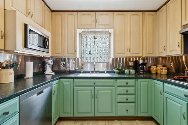 a kitchen with stainless steel appliances granite countertop a sink a microwave counter space and cabinets