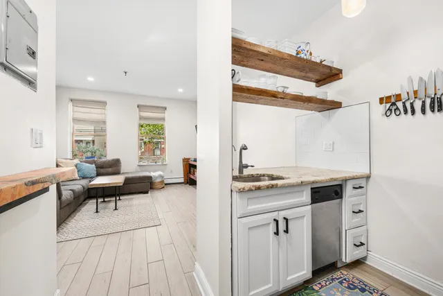 a living room with furniture and a open kitchen view