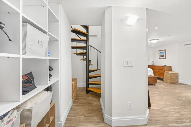 a view of a hallway with wooden floor and entryway