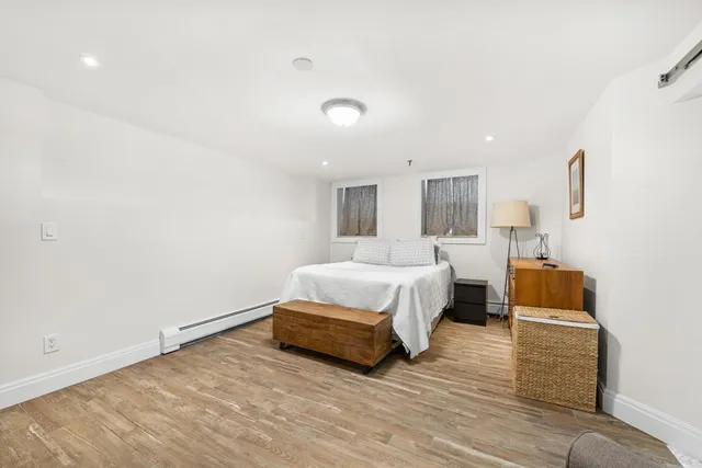 a spacious bedroom with a bed and wooden floor