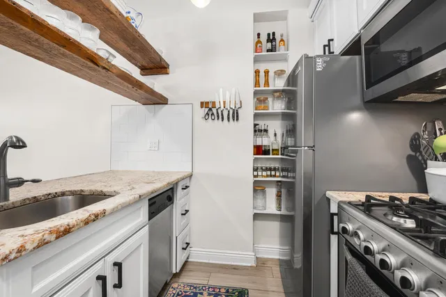 a kitchen with stainless steel appliances granite countertop a refrigerator and a stove