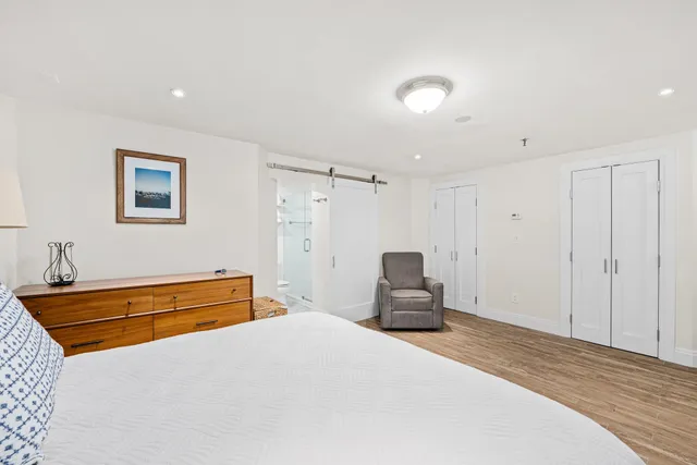 a bedroom with a bed and a painting on the wall