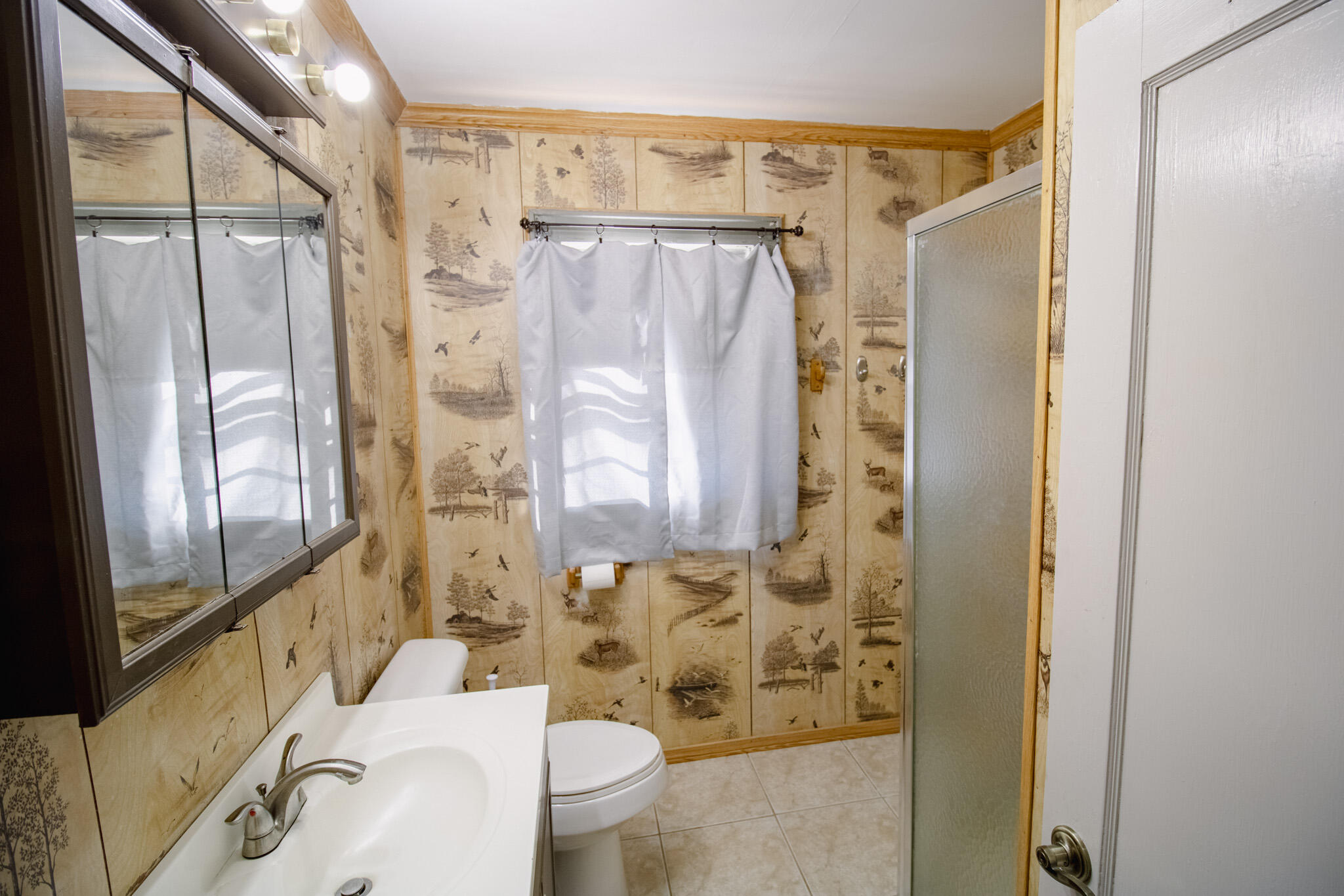 3114 Baylor Street Lubbock, TX 79415 - Photo 7 of 11 a bathroom with a shower curtain and a sink