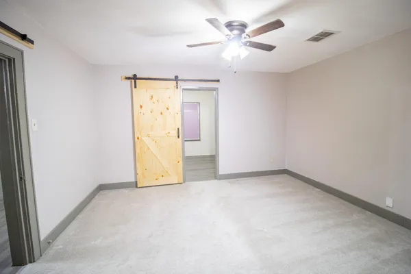 an empty room with a ceiling fan and a window