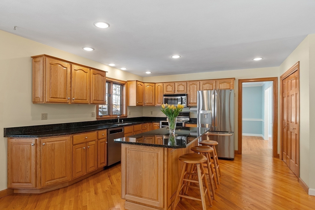 220 Hayden Road Groton, MA 01450 - Photo 14 of 37 a kitchen with stainless steel appliances granite countertop a stove top oven a sink dishwasher and a microwave with wooden floor