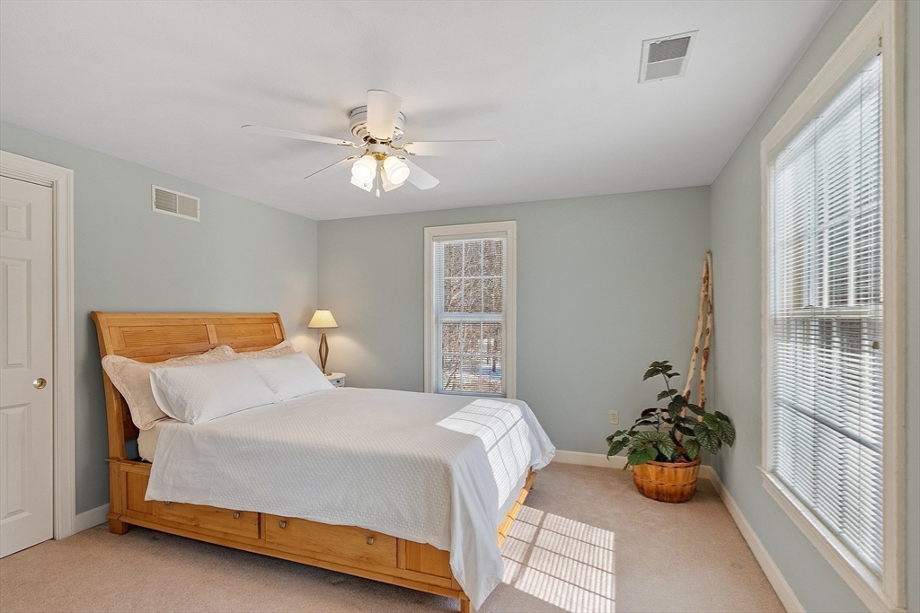 220 Hayden Road Groton, MA 01450 - Photo 29 of 37 a bedroom with a bed and a chandelier