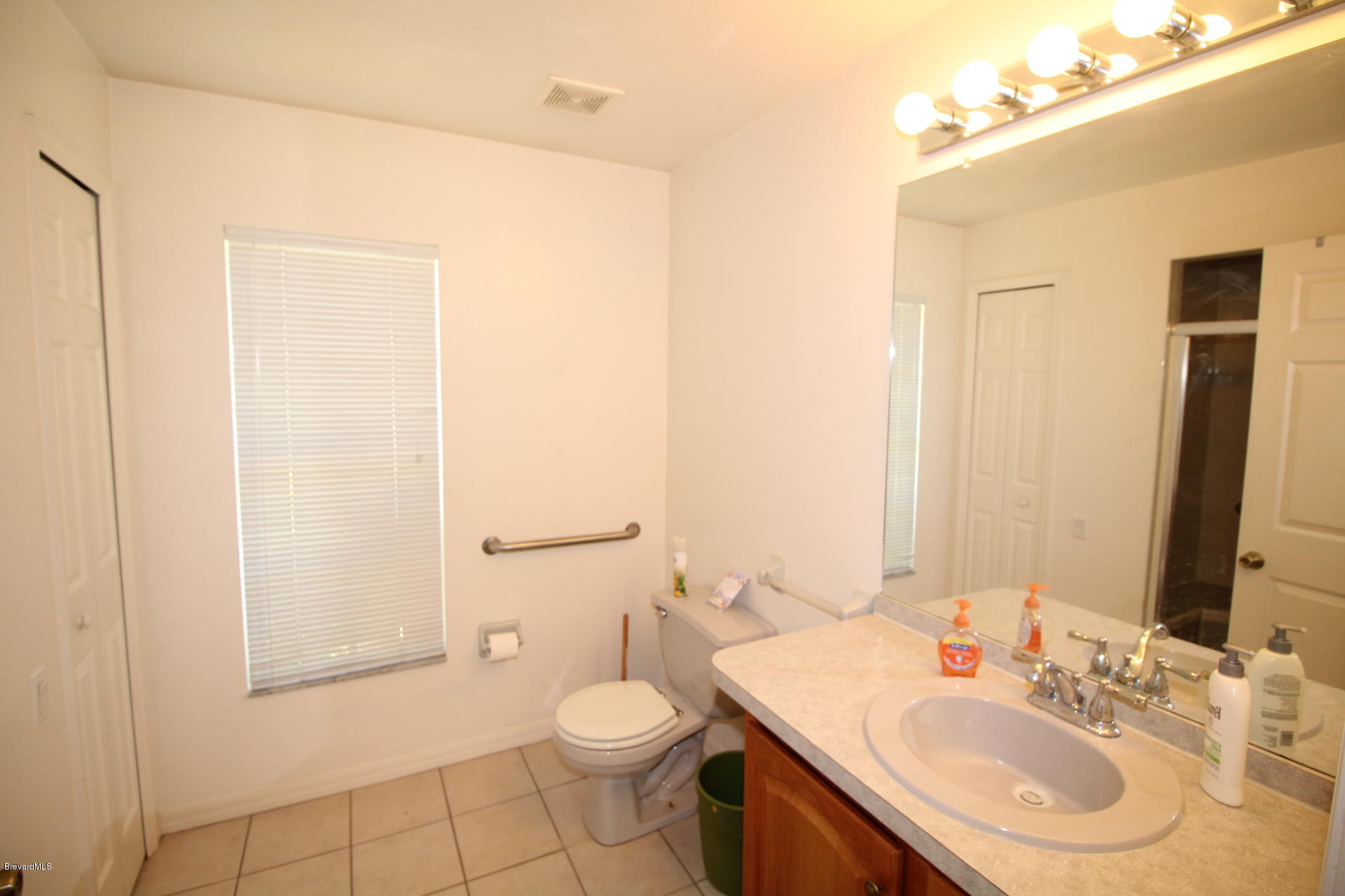 724 Riviera Drive Northeast Palm Bay, FL 32905 - Photo 5 of 13 a bathroom with a sink a toilet and shower
