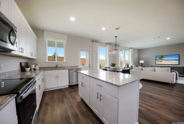 a kitchen with a sink stove cabinets and wooden floor