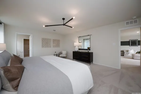a spacious bedroom with a bed a couch and a view of en suite bathroom