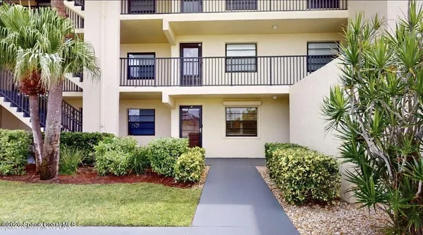 a front view of multi story residential apartment building with yard and entryway